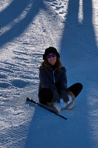 Portrait of young woman standing on snow covered field