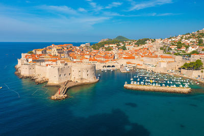 High angle view of buildings by sea against sky