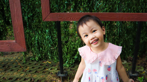 Portrait of smiling girl standing against plants