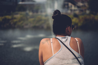 Rear view of woman against fountain in public park