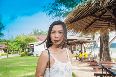 Portrait of mid adult woman standing at beach against sky