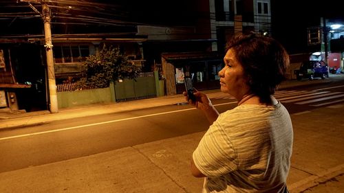 Side view of woman looking at city street