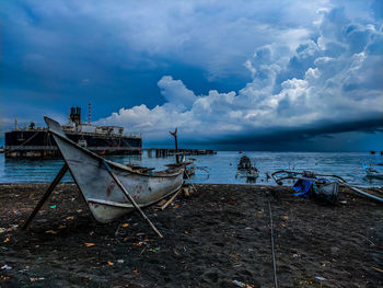 Fishing boats moored on sea against sky