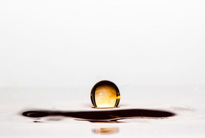 Close-up of wet glass against white background