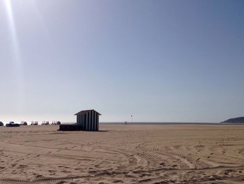 Scenic view of beach against clear blue sky