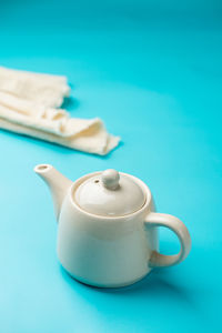 Ceramic teapot on light blue background