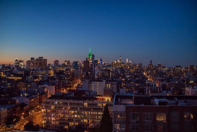 View of city lit up against blue sky