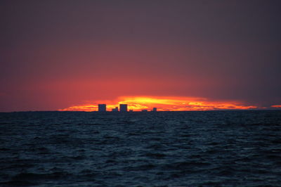 Scenic view of sea against dramatic sky during sunset