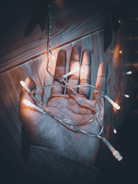 Close-up of hand holding burning candles