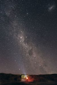 Person standing with flashlight at night