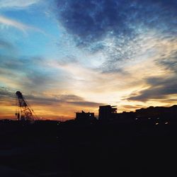 Silhouette of building against dramatic sky