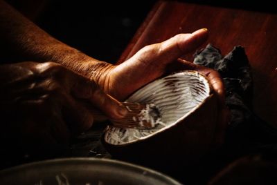 Cropped hands of person removing coconut from shell