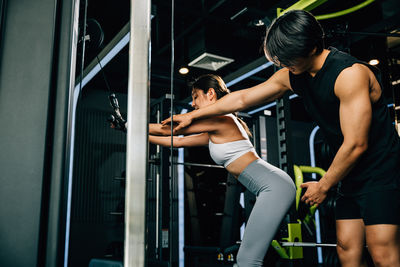 Side view of woman exercising in gym