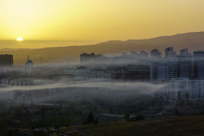 Buildings in city during sunset