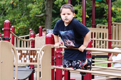 Portrait of boy sitting on railing