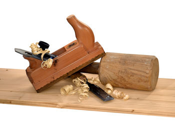 Close-up of old tools on table against white background