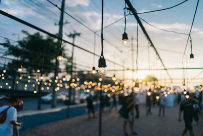 People on illuminated street lights in city at dusk