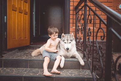 Portrait of girl with dog sitting outdoors