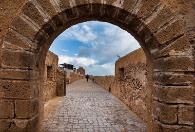 Stone wall of old building against sky