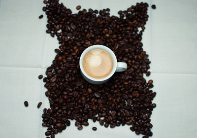 Coffee cup surrounded by coffee beans