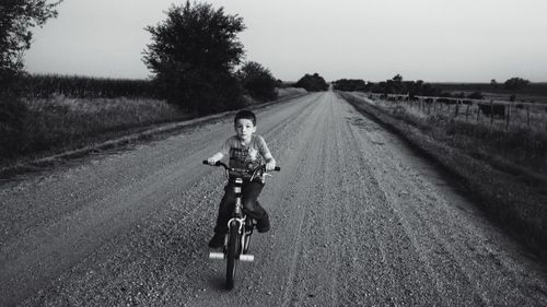 View of boy cycling on road