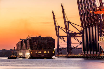 View of illuminated ship in sea against sky during sunset