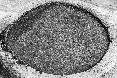 High angle view of manhole on concrete wall