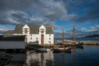 Sailboats moored in lake against sky