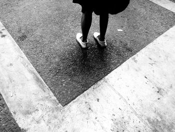 Low section of man standing on zebra crossing