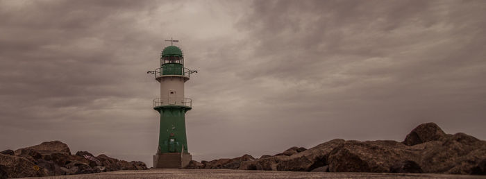 Low angle view of lighthouse amidst buildings against sky