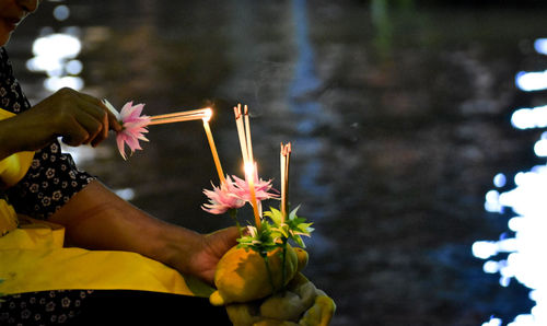 Low angle view of hand holding flowers