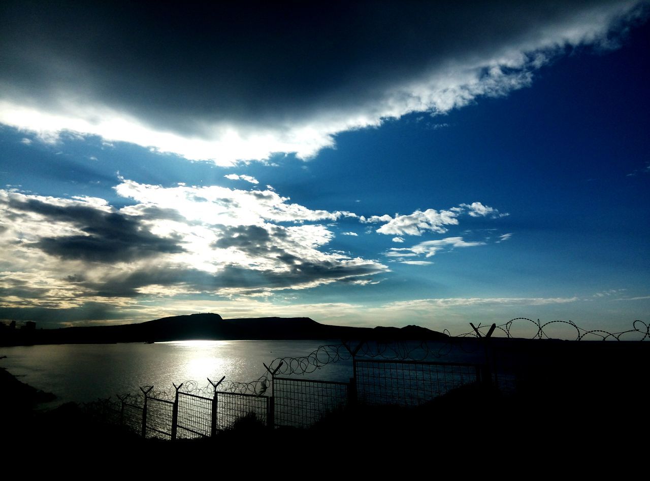 sky, water, tranquil scene, tranquility, scenics, cloud - sky, beauty in nature, silhouette, nature, cloud, sea, lake, cloudy, idyllic, reflection, sunset, calm, blue, mountain, outdoors