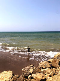 Scenic view of rocks on beach against sky