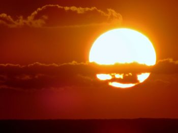 Silhouette landscape against orange sky