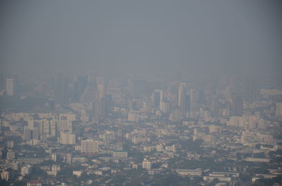 Aerial view of buildings in city against sky