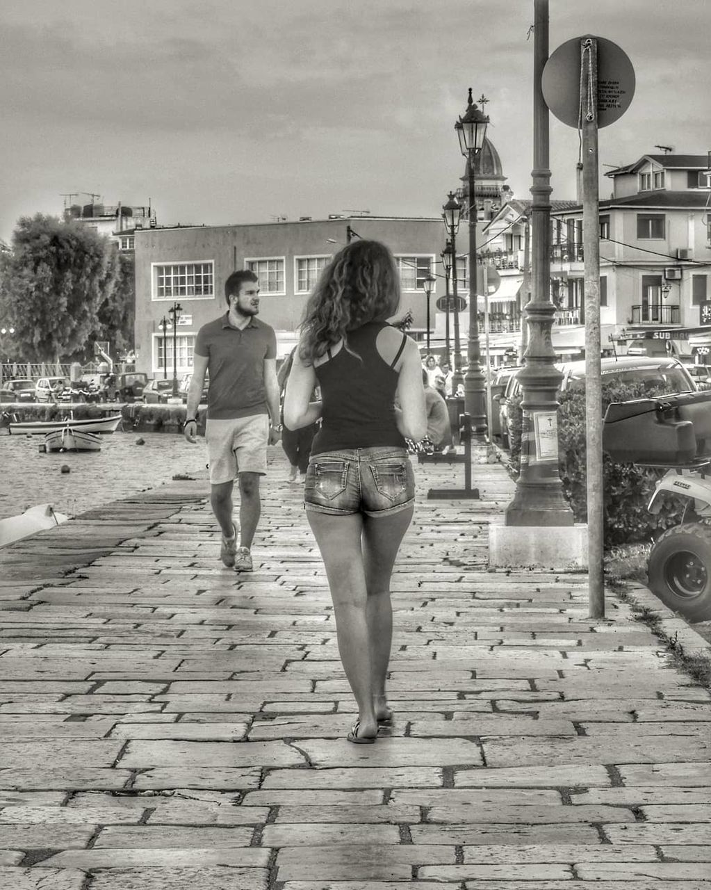 full length, real people, architecture, building exterior, rear view, women, built structure, lifestyles, two people, adult, young women, walking, young adult, city, togetherness, people, day, leisure activity, standing, street, outdoors, hairstyle, shorts