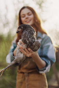Portrait of woman holding bird