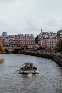 Boat in river against buildings in city