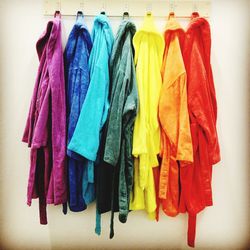 Close-up of colorful bathrobes hanging from hooks