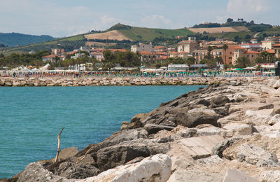 Scenic view of sea by town against sky