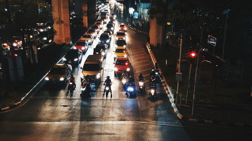 Vehicles on road along buildings at night