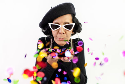 Portrait of woman wearing sunglasses against white background