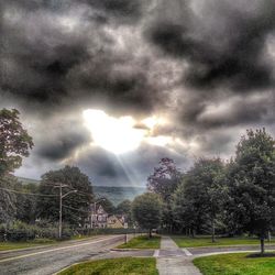 Road passing through landscape against cloudy sky