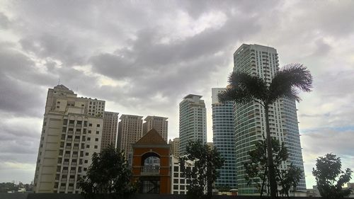 Low angle view of modern building against cloudy sky