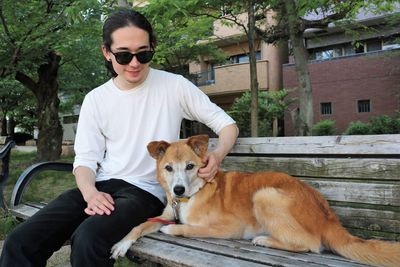 Portrait of young man with dog on field