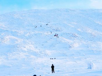 People on snow covered mountain against sky