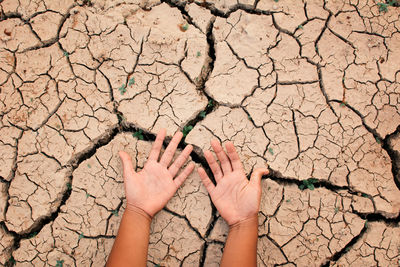 Cropped hands on barren land