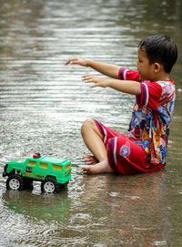 Boy playing with toy in water