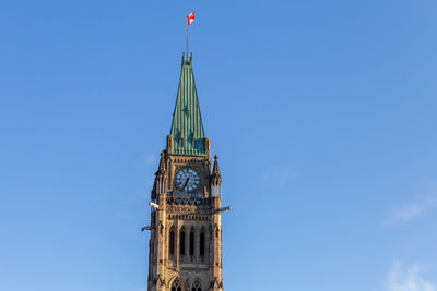 Low angle view of clock tower against blue sky