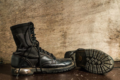 Close-up of leather shoes on floor against wall